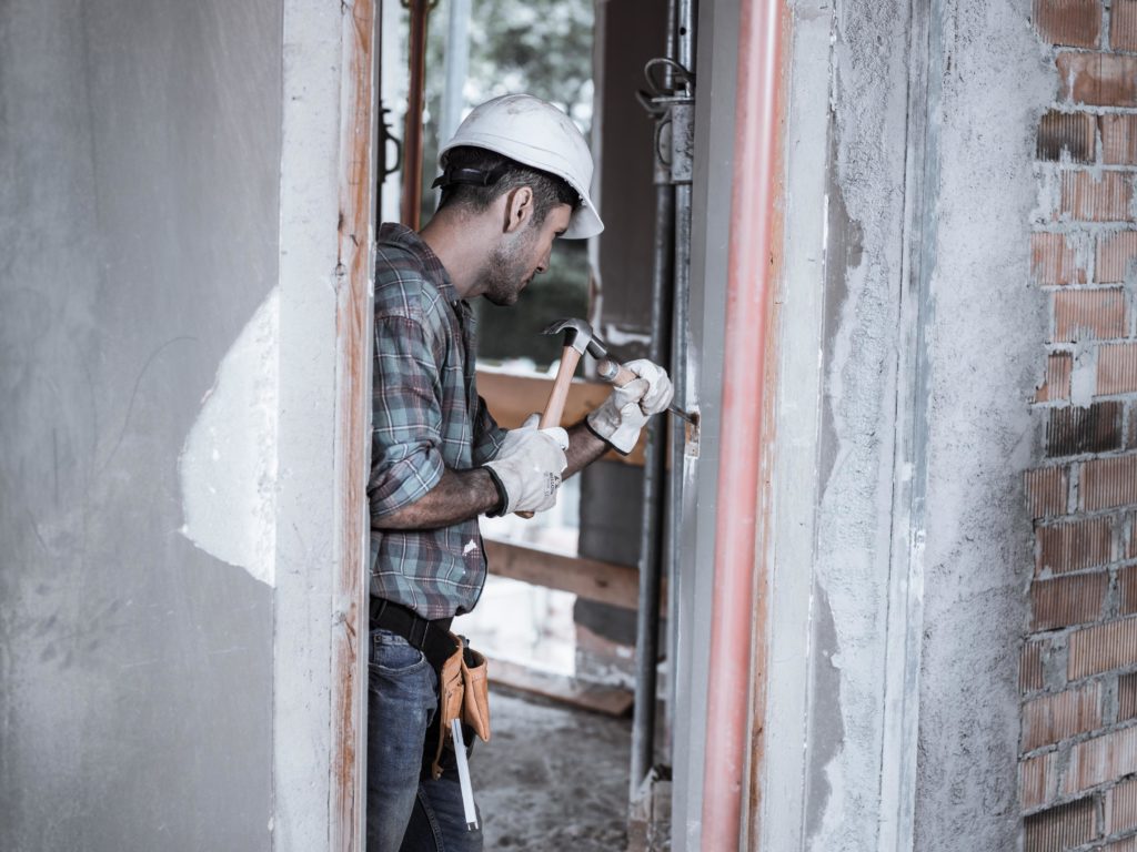 Carpintero haciendo agujero en madera con martillo