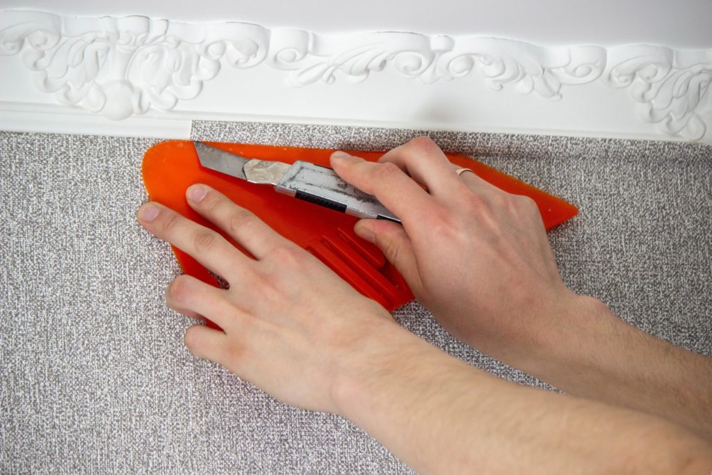 hombre pega papel tapiz